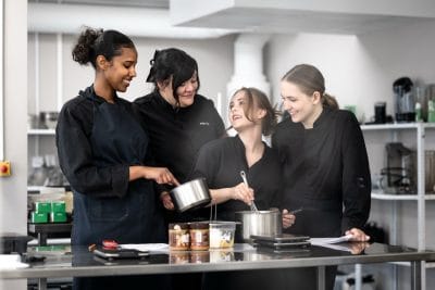En grupp elever får instruktioner av bageriläraren.