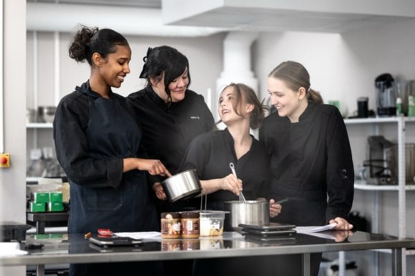 En grupp elever får instruktioner av bageriläraren.