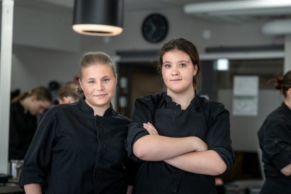 Två tjejer i konditoriet ser in i kameran.